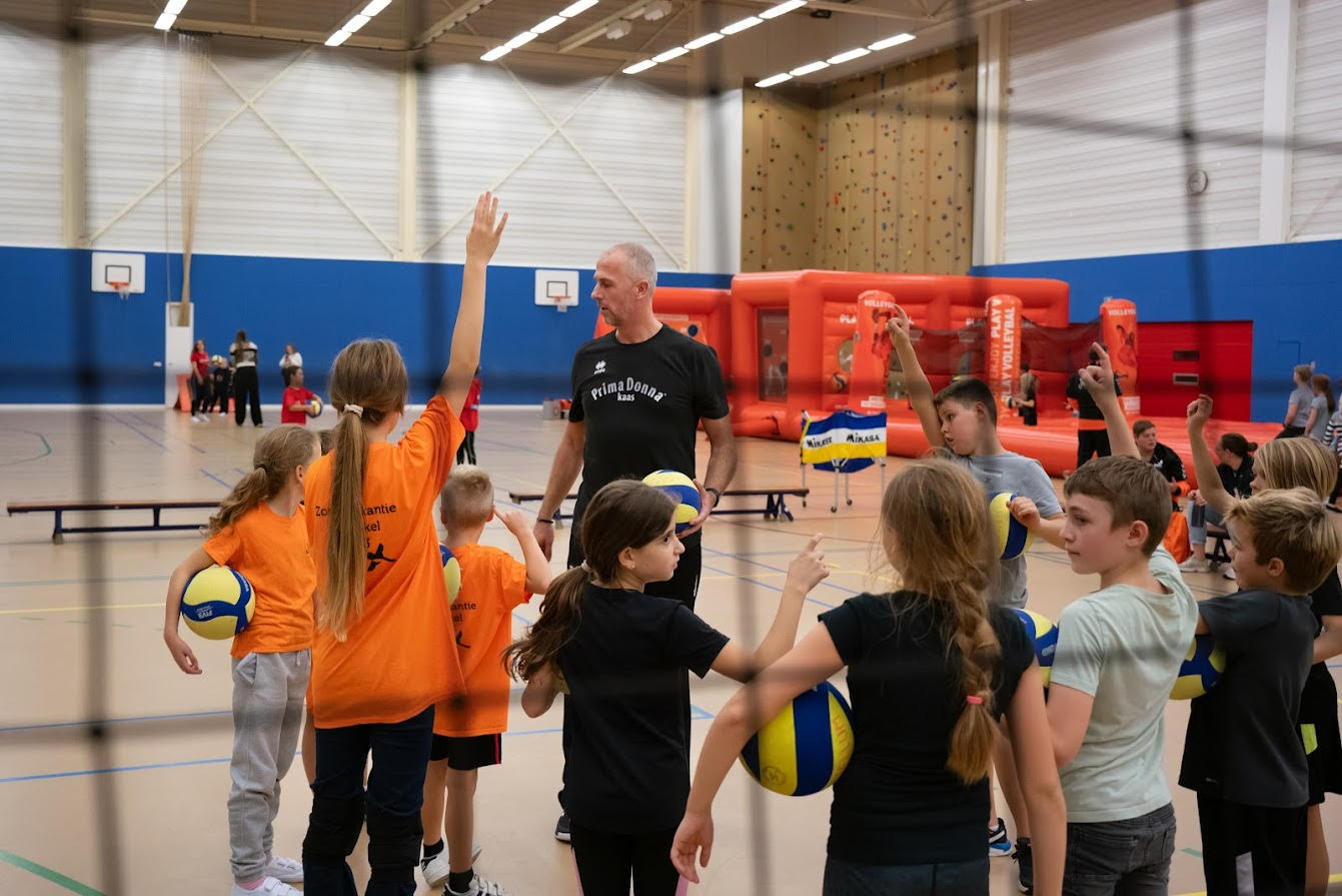 Hans Vreelink, trainer van de Prima Donna Volleybal school geeft een clinic aan kinderen van Junis Kinderopvang.